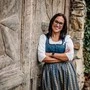 Eine junge Dame lächelt in einem Dirndl in die Kamera  | Chorleiterin Desirée Deiser 