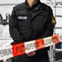 Augsburg, Bavaria, Germany - October 18, 2024: A police officer stands behind a police barrier at the career information day of the Swabia North Police Headquarters in Augsburg *** Ein Polizeibeamter steht hinter einer Polizeiabsperrung am Berufsinformationstag vom Polizeipräsidium Schwaben Nord in Augsburg
