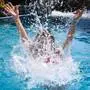Eine Person springt in einen Pool.