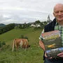Der Griffner Autor Valentin Hauser mit seinem neuen Buch vor seinem Heimatort Greutschach
