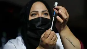 An Israeli health worker prepares to administer a third dose of the Pfizer-BioNtech Covid-19 vaccine to Jewish ultra-Orthodox people at a religious neighbourhood in Jerusalem on August 19, 2021. - Israelis aged 40 and over will be able to receive coronavirus vaccine booster shots starting this weekend, Health Minister Nitzan Horowitz said, as the country battles a spike in infections. Israel was one of the first countries to launch a vaccination drive in mid-December via an agreement with Pfizer to obtain millions of paid vaccine doses in exchange for sharing data on their effectiveness. (Photo by Ahmad GHARABLI / AFP)