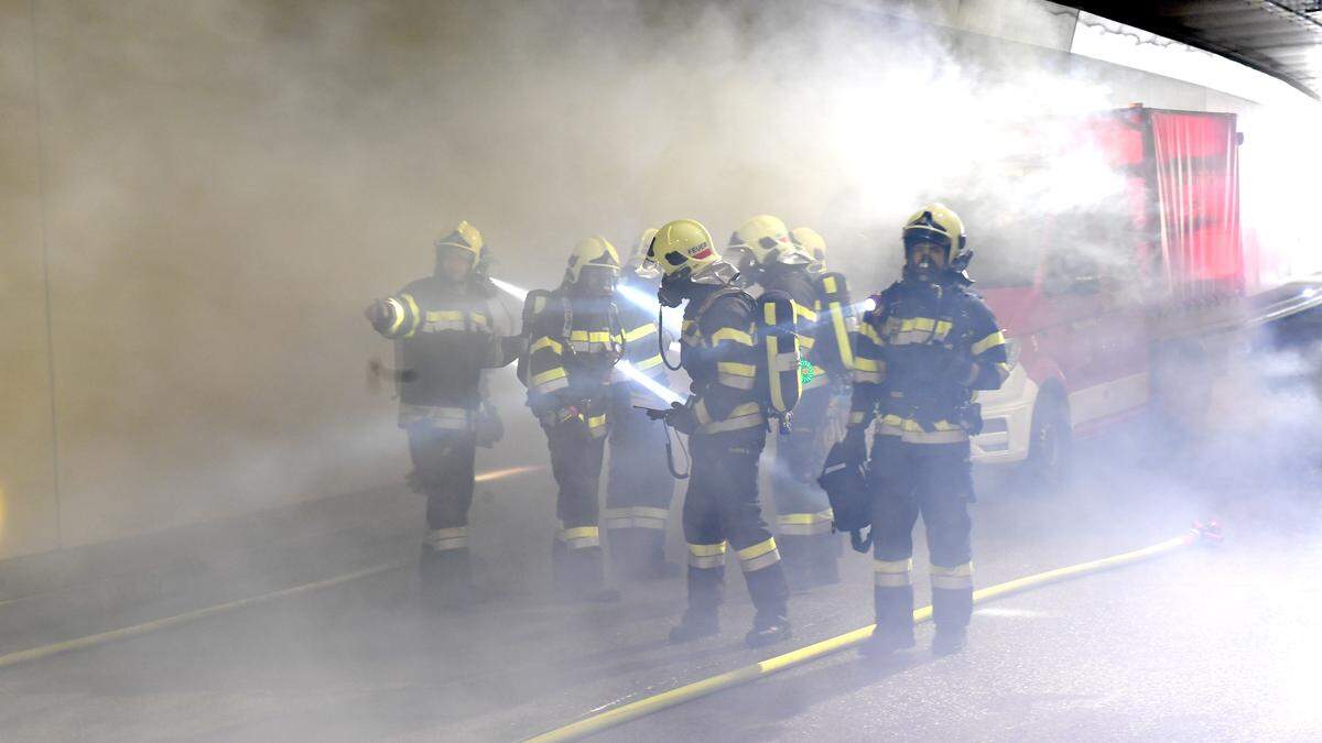 Im völlig verrauchten Tunnel - für die Übung wurde dieser mit einer Nebelmaschine erzeugt - sind die Feuerwehrleute im Einsatz 