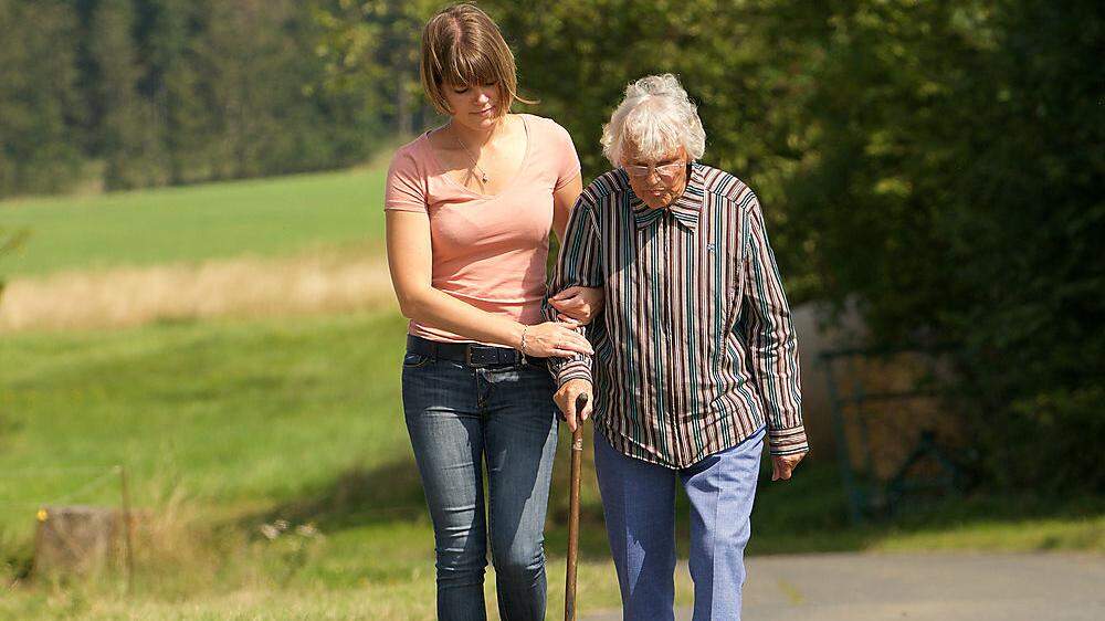 Frau hilft Seniorin