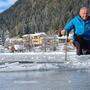 Eismeister Norbert Jank zeigt mit dem Bohrer die Höhe der Eisverschiebung an