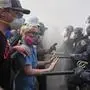 Protesters confront police on the 101 Freeway near the metropolitan detention center of downtown Los Angeles, Sunday, June 8, 2025, following last night's immigration raid protest. (AP Photo/Jae C. Hong)
