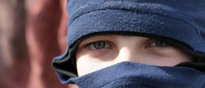 Ein Kind mit blauen Augen und einer dunkelblauen Sturmhaube.
