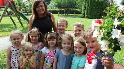 Kindergartenleiterin Eva Nuart und die Kinder haben sich um drei Blumenampeln gekümmert