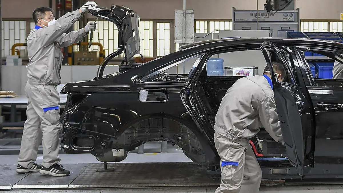 In this Feb. 17, 2020, photo and released by Xinhua News Agency, workers assemble Audi A6 L cars at a workshop of FAW-Volkswagen Automobile Co., Ltd. in Changchun, northeast China's Jilin Province, Automakers are reopening factories in China that were idled by anti-virus controls as they try to reverse a sales slump in their biggest market. (Zhang Nan/Xinhua via AP)