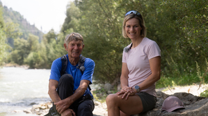 Walter Mair und Marlies Raich sitzen auf Steinen am Iselufer