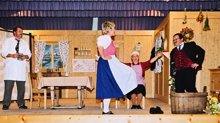 Ein Theaterstück mit vier Personen in Tracht auf der Bühne