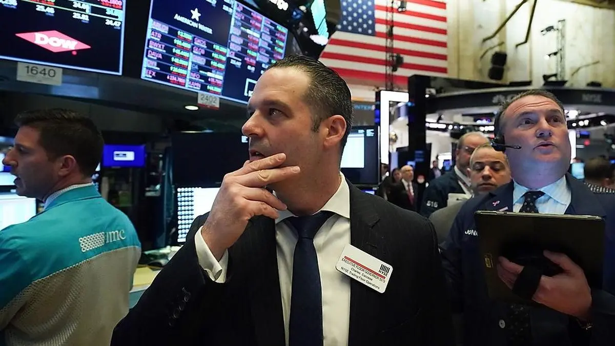 A Floor Governor looks on as traders work on the floor at the opening bell of the Dow Industrial Average at the New York Stock Exchange on March 12, 2020 in New York. - Wall Street stocks were deep in the red early Thursday, resuming after a 15-minute suspension as the economic pain from the coronavirus deepens and widens. About 25 minutes into trading, the Dow Jones Industrial Average was at 21,505.07, down more than 2,000 points or 8.7 percent. (Photo by Bryan R. Smith / AFP)
