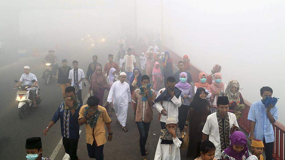 Die Menschen in Indonesien schützen sich gegen den Smog