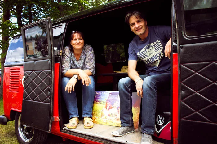 „Unser Bulli ist ein ehemaliges Feuerwehrauto, das 38 Jahre vor einer Scheune gestanden hat, bevor wir es dann 2008 gekauft haben. Ursprünglich kommt es aus der Feuerwache in Friesnitz-Rosenbach. Und wir waren schon immer große VW-Fans. Da war der Bulli eine Herzensangelegenheit, inzwischen haben wir schon einiges mit ihm erlebt. Sogar Fotomodell war er schon. Natürlich ist er nicht unser erstes Auto. Rund 40 Stück hatte Thomas schon, inzwischen steht beim Versicherungsmakler schon ein Kaffee am Tisch, wenn er einen Termin hat. Am Treffen sind wir beide eigentlich jedes Jahr, wir haben ja den Heimvorteil und drehen abends oft einfach noch eine gemütliche Runde. Besonders schön finden wir, dass man hier so viele nette Leute, Gleichgesinnte mit ähnlichen Interessen kennenlernt. Warum VW so viele Fans hat? Wir denken, weil es einfach ein Auto fürs Volk ist. Auch sonst fahren wir einen VW – was sonst?“
