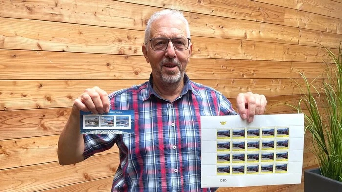 Mann mit Briefmarken in der Hand