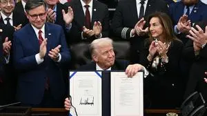 TOPSHOT - US President Donald Trump (C) shows the signed bill package to re-open the federal government as the Speaker of the House Mike Johnson (L) and other Republican leaders applaud in the Oval Office of the White House in Washington, DC, on November 12, 2025. Congress on Wednesday ended the longest government shutdown in US history, 43 days that paralyzed Washington and left hundreds of thousands of workers unpaid while Republicans and Democrats played a high-stakes blame game. The Republican-led House of Representatives voted largely along party lines to approve a Senate-passed package that will reopen federal departments and agencies, as many Democrats fume over what they see as a capitulation by party leaders. (Photo by Brendan SMIALOWSKI / AFP)