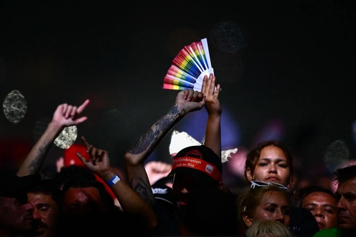 A fan holds up a rainbow fan as US pop star Madonna performs during a free concert at Copacabana beach in Rio de Janeiro, Brazil, on May 4, 2024. . Madonna ended her The Celebration Tour with a performance attended by some 1.5 million enthusiastic fans. (Photo by Pablo PORCIUNCULA / AFP)