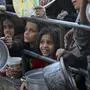 Displaced Palestinians collect food donated by a charity before an iftar meal, the breaking of the fast, on the first day of the Muslim holy fasting month of Ramadan in Rafah, on the southern Gaza Strip on March 11, 2024, amid ongoing battles between Israel and the militant group Hamas. (Photo by AFP)