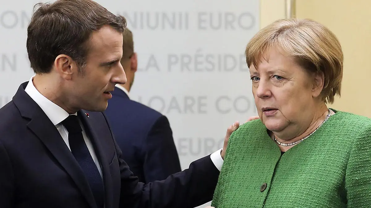 German Chancellor Angela Merkel, right, speaks with French President Emmanuel Macron, center, during a round table meeting at an EU summit in Sibiu, Romania, Thursday, May 9, 2019. European Union leaders on Thursday start to set out a course for increased political cooperation in the wake of the impending departure of the United Kingdom from the bloc. (Ludovic Marin, Pool Photo via AP)