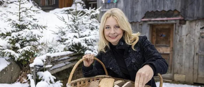 Iva Schell mit einem Korb voller Holz | In und um die Hütte gibt es für Iva Schell viel Arbeit, aber sie genießt das Leben in Preitenegg
