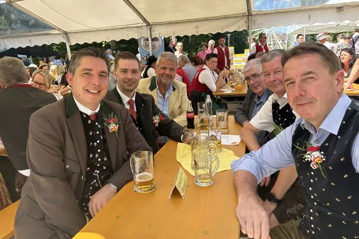 Die Ehrengäste des Spittaler Kirchtags genießen das sonnige Wetter und stoßen auf einen gelungenen Bieranstich an.