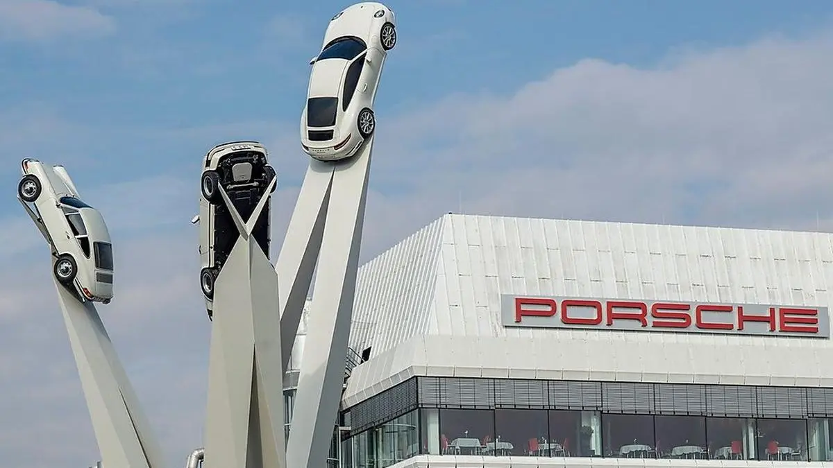 (FILES) In this file photo taken on February 21, 2019 the sculpture "Inspiration 911", showing three Porsche 911 sportscars from different generations is seen in front of the headquarters of German luxary carmaker Porsche AG in Stuttgart, southwestern Germany. - German auto giant Volkswagen on February 22, 2022 said it was drawing up plans to list its luxury brand Porsche as it looks to raise the funds for its move to electric vehicles. Volkswagen and its largest shareholder Porsche SE had "negotiated a framework agreement which should form the basis for further steps" towards a separate stock market listing, the carmaker said in a statement. (Photo by THOMAS KIENZLE / AFP)
