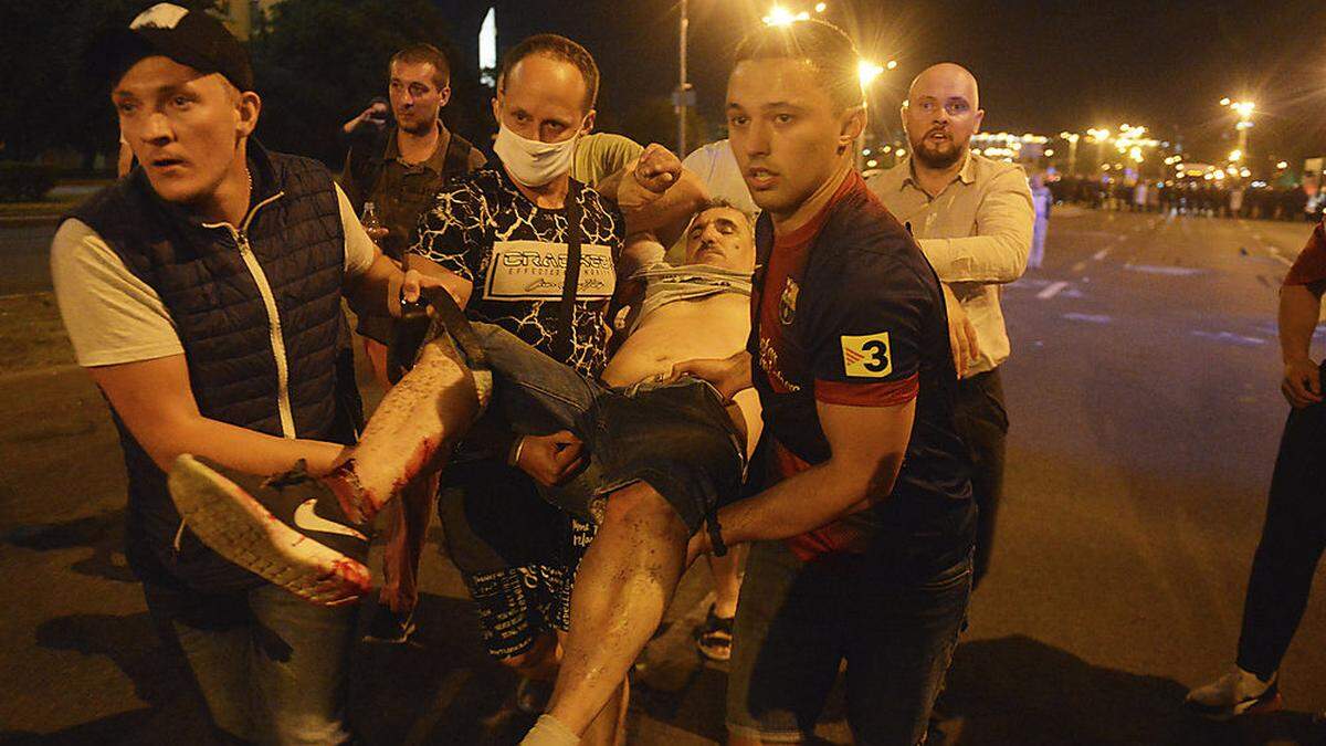 Protestierende helfen einem Verwundeten - Beamte gingen mit Schlagstöcken auf die Demonstranten los 