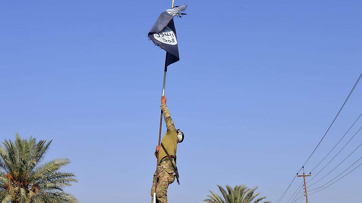 Ein irakischer Soldat nimmt die IS-Flagge ab, nach einem Sieg über die Miliz bei Ramadi