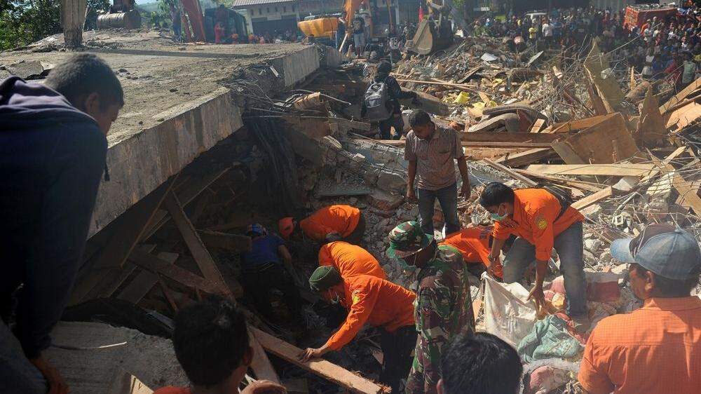 Helfer graben unter den Trümmern nach Überlebenden 