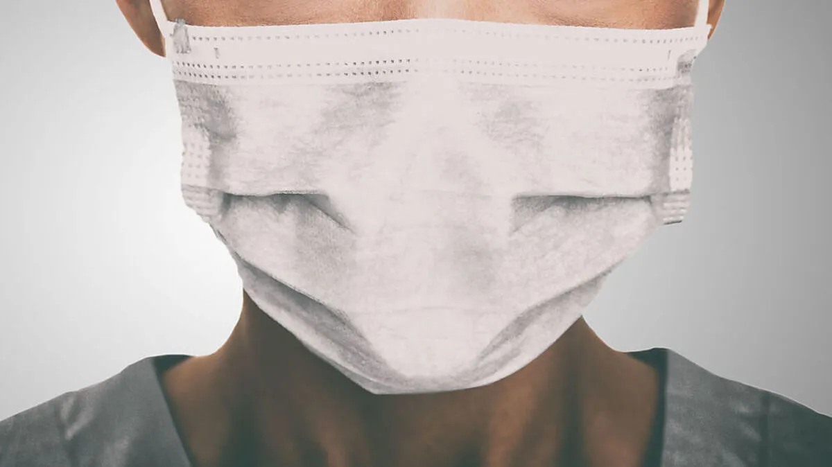 Doctor wearing protection face mask against coronavirus. Banner panorama medical staff preventive gear.
