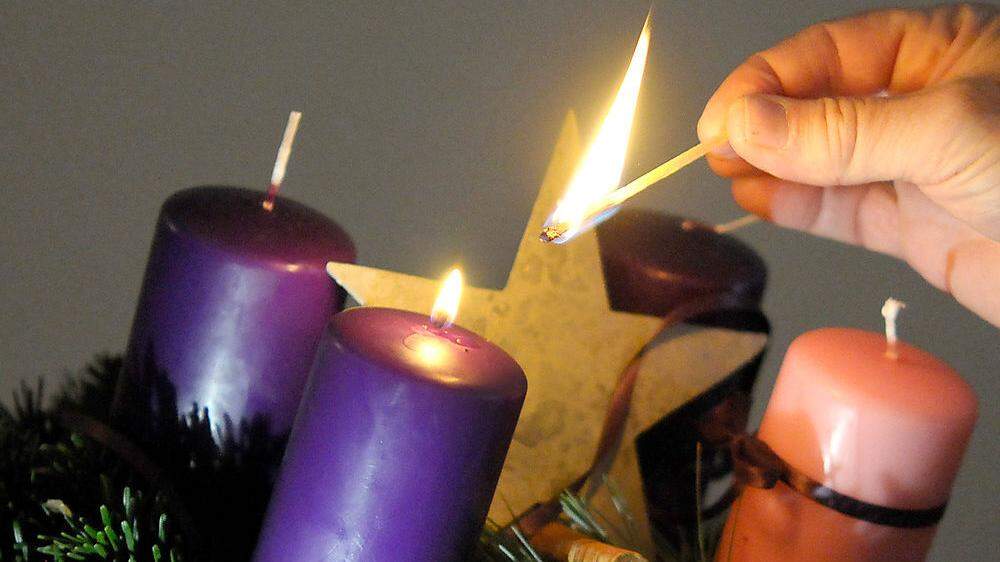 Am Adventkranz wird die erste Kerze entzündet, die dritte ist laut christlicher Tradition rosarot - und lädt dazu ein, sich zu freuen