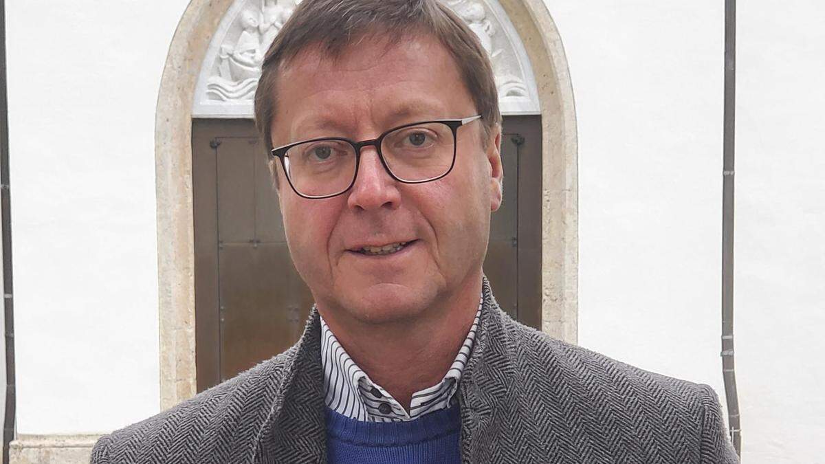Dekan Franz Troyer signiert seinen Kirchenführer am Adventmarkt 