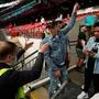 A steward speaks to fans, who don't have a ticket, ahead of the UEFA EURO 2020 final football match between Italy and England at the Wembley Stadium in London on July 11, 2021. (Photo by JOHN SIBLEY / POOL / AFP)
