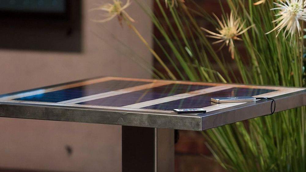 Ein Tisch, der Smartphones mit Sonnenenergie lädt