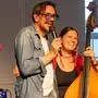 Ein Mann mit Mikrofon und eine Frau mit Kontrabass | Christian Stani und Bassistin Romina Denaro von Alle Achtung