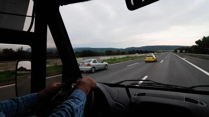 Blick aus der Frontscheibe eines Reisebusses auf einer Autobahn.