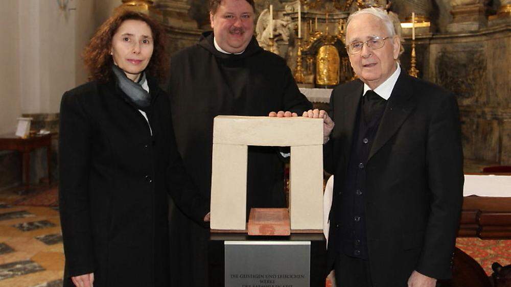 Roswitha Dautermann mit Pater Egon und Seelsorger Josef Gölles vor ihrem Kunstobjekt.