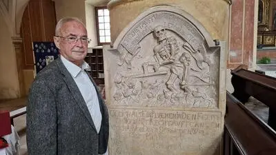 Der Gleisdorfer Historiker Robert F. Hausmann  in der Stadtpfarrkirche St. Laurentius vor der Gedenktafel der 1677 begrabenen Katharina Regina Buetschaher, die mit 18 Jahren starb.