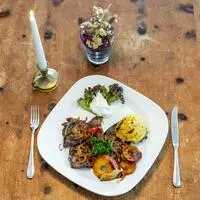 Gegrillte Leber mit Zwiebeln, Apfelscheiben, Tomaten und Röstkartoffeln.