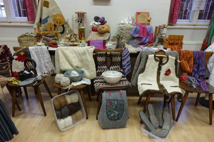 Am großen Ausstellungstisch drängen sich handgefertigte Produkte. Gestrickte Socken, Naturwolle, Katzenspielzeug, modische Jacken, gehäkelte Lamas, kunstvolle Decken und Teppiche, alles mit viel Liebe von den Damen produziert.
