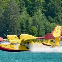 Eine italienische Canadair-Maschine nimmt Löschwasser im Weißensee auf