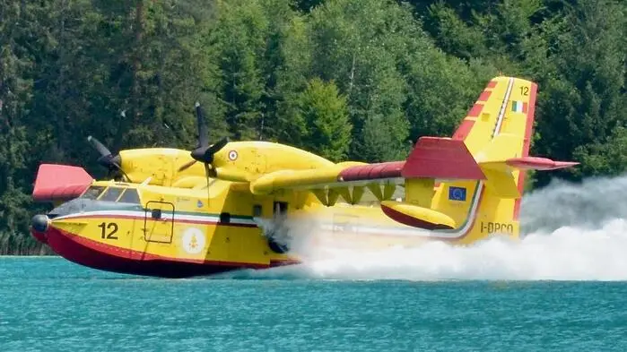 Eine italienische Canadair-Maschine nimmt Löschwasser im Weißensee auf
