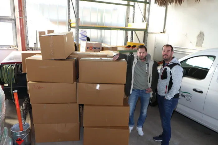Jürger Rainer und Alexander Pluch (am Foto von Links) brachten zwei Hänger voll Kartons mit Wäsche, die sie vorher  drei Tage lang in Steuerberg von der Bevölkerung eingesammelt bzw. gebracht bekommen hatten, heute zum Bauhof nach Feldkirchen.