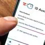 Ein Finger drückt auf die in einem Smartphone geöffnete ID-Austria-App