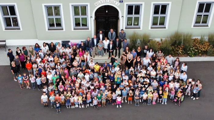 Sowohl Lehrerinnen und Lehrer als auch die Schülerinnen und Schüler würden staunend, mit leuchtenden Augen durch das erneuerte Schulgebäude gehen, sagt der Direktor. Hier stehen sie vor der neuen Fassade ihrer Schule
