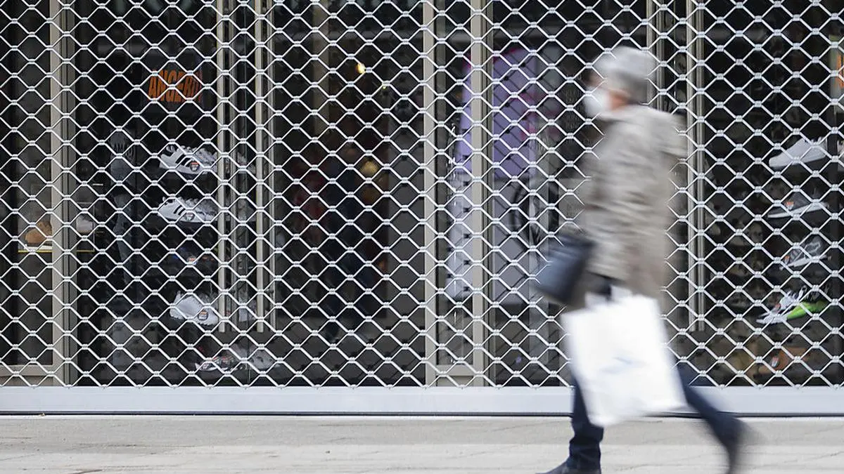 ABD0003_20210102 - STUTTGART - DEUTSCHLAND: ARCHIV - 18.12.2020, Baden-Württemberg, Stuttgart: Eine Frau mit einer Einkaufstasche geht an einem geschlossenen Laden in der Königsstraße vorbei. Der Handel rechnet nicht mit einem raschen Ende der coronabedingten Ladenschließungen in Deutschland. (zu dpa «Corona: Handel erwartet keine schnelles Ende der Ladenschließungen») Foto: Tom Weller/dpa +++ dpa-Bildfunk +++. - FOTO: APA/DPA/TOM WELLER