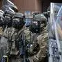 Members of the California National Guard and police officers wear gas masks as they stand guard at the loading dock of the Roybal Federal Building in downtown Los Angeles, on June 12, 2025. A judge has ordered Donald Trump to return control of the California National Guard to the state, saying the president's decision to deploy them to protest-hit Los Angeles over Governor Gavin Newsom's objections was "illegal." Protests against Donald Trump's harsh immigration policies spread on June 11 across the United States despite a military-backed crackdown in Los Angeles and threats by the hard-right Republican president to use "heavy force." (Photo by Robyn Beck / AFP)