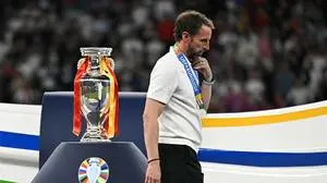(FILES) England's head coach Gareth Southgate walks with his silver medal past to the trophy after  the UEFA Euro 2024 final football match between Spain and England at the Olympiastadion in Berlin on July 14, 2024. Gareth Southgate said he is resigning as England manager on July 16, 2024 two days after they lost to Spain in the Euro 2024 final. "It's time for change, and for a new chapter. Sunday's final in Berlin against Spain was my final game as England manager," he said in statement. (Photo by JAVIER SORIANO / AFP)