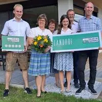 Die stolzen Hausherren und -damen mit der Auszeichnung „5-Blumen-Betrieb“