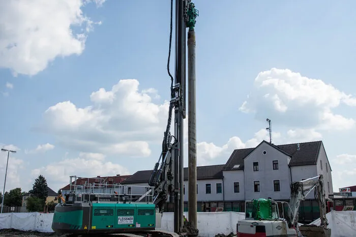 Hinter dem Innovationszentrum werden gerade Löcher gebohrt, sodass dann die Eisenwände zur Sicherung der Baugrube in die Erde gerammt werden können.