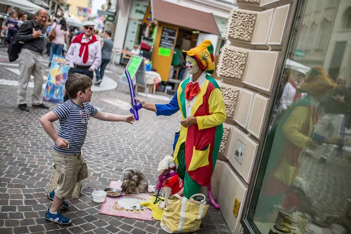 Clowns verteilen Luftballons an Kinder
